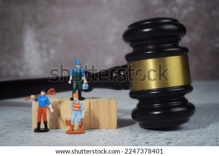 Selective focus image of miniature with gavel and law wording. Labour law concept Royalty-Free Stock Photo #2247378401