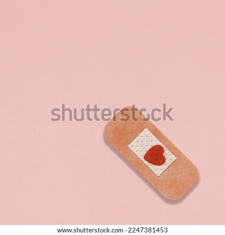 Creative composition made with medic plaster with heart shaped stain on pastel pink background. Minimal concept of broken heart, romantic suffering or valentines concept. Flat lay, greeting card. Royalty-Free Stock Photo #2247381453