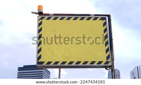 Blank yellow Billboard with black striped on the sideway in the park. image for copy space, advertisement, text and object. Purple billboard in natural green.