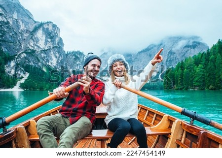 Mountain stories. Happy couple on a wanderlust vacation. Boyfriend and girlfriend spending time together at the lake. Storytelling concept about lifestyle and winter travels Royalty-Free Stock Photo #2247454149