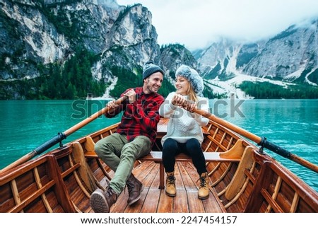 Mountain stories. Happy couple on a wanderlust vacation. Boyfriend and girlfriend spending time together at the lake. Storytelling concept about lifestyle and winter travels Royalty-Free Stock Photo #2247454157