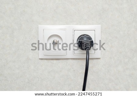 A plug with a wire is plugged into the socket.
