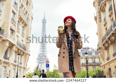 Beautiful young woman visiting paris and the eiffel tower. Parisian girl with red hat and fashionable clothes having fun in the city center and landmarks area Royalty-Free Stock Photo #2247464127
