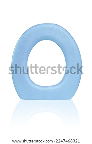 Close-up shot of a green foam toilet seat cushion. The padded comfortable toilet seat is isolated on a white background. Front view. Royalty-Free Stock Photo #2247468321