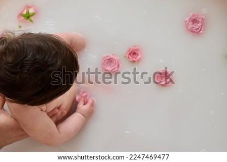 Candid photography. Milk and roses for baby bath.