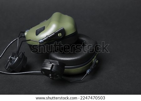 Tactical headphones on black background, closeup. Military training equipment
