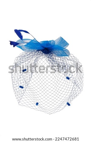 Close-up shot of a dark blue fascinator with a multi layered bow and a veil decorated with feathers. The fascinator with an alligator clip is isolated on a white background. Front view. Royalty-Free Stock Photo #2247472681
