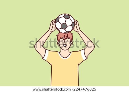 Teenage boy raises soccer ball over head dreams of becoming professional football player and playing in Major League. Young guy in yellow T-shirt stands on green lawn. Flat vector illustration Royalty-Free Stock Photo #2247476825