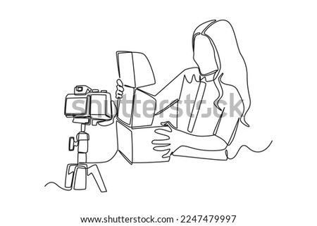 Continuous one line drawing happy girl recording unboxing video on camera. Vlogging concept. Single line draw design vector graphic illustration.