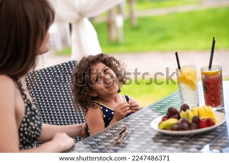 Mom and daughter having fruits and looking happy