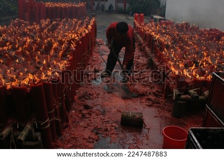                            a worker is cleaning the temple from a spill of melted ceremonial candles     