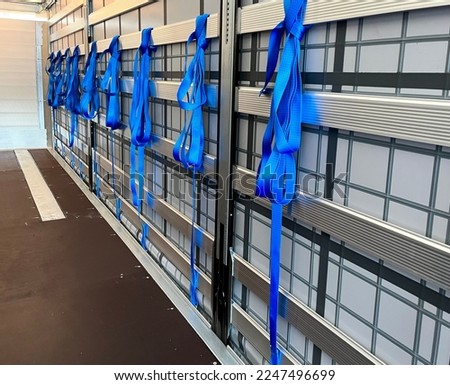 View inside the semi-trailer. Tie straps for securing loads hang on the side aluminum boards Royalty-Free Stock Photo #2247496699