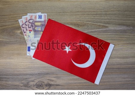Coins and Turkey flag placed on wooden background.