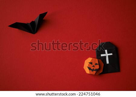 Halloween symbols origami bat and pumpkin on a red background