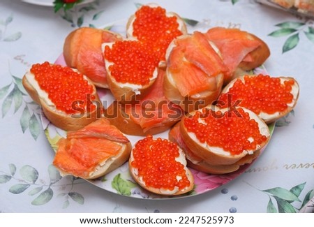 Sandwiches with red caviar and and salmon on white bread on a plate. New year composition. Homemade food