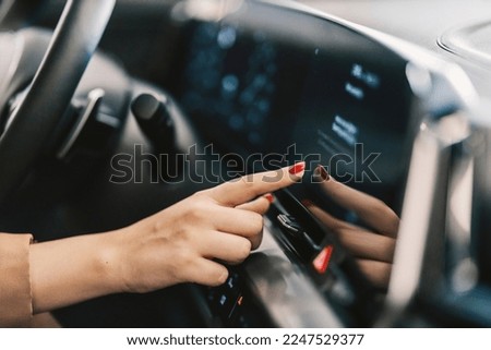 Hand pressing touchscreen in car.