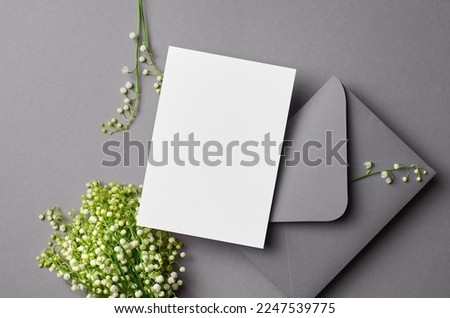 Wedding invitation card mockup with envelope and lily of the valley flowers, card with copy space