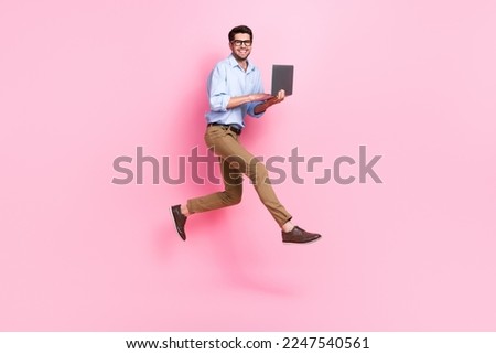 Full body size photo of jump professional freelance copywriter guy wear office clothes hold his new corporate laptop isolated on pink color background