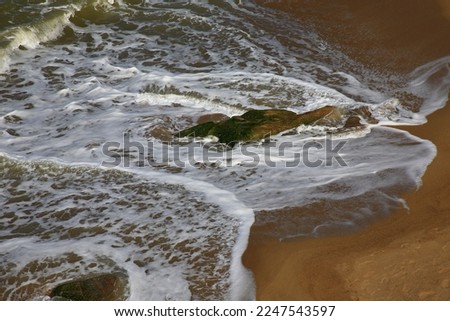 picture of moving wave in sea on rock stone blur background, Wave on rock sand beach at Ao Manao Beach, Narathiwat Province,Thailand