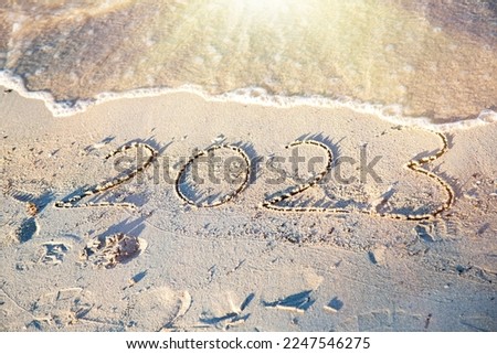 2023 on sand with waves and sun light 