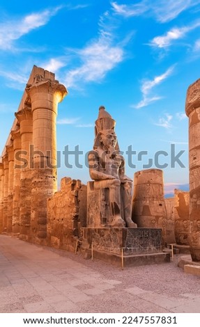 Seated statue of Ramesses II by the First pylon of the Luxor Temple, Egypt Royalty-Free Stock Photo #2247557831