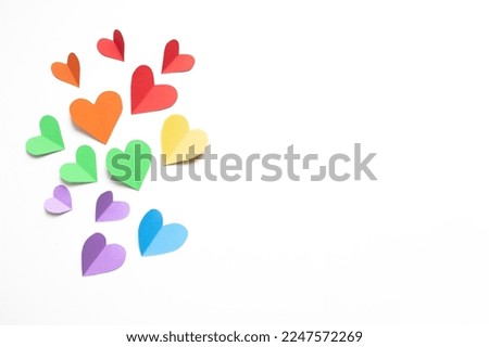 
frame composition with rainbow colored paper hearts  on a white background. concept of valentine's day, lgbt, pride month. copy space. flat lay. top view.