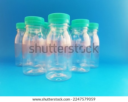 A collection of multi-purpose transparent bottles with colored caps, standing and arranged