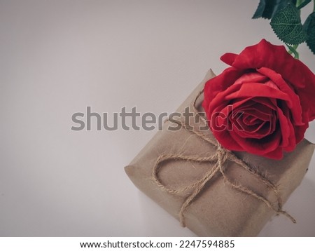 Red roses and brown gift box on white paper for Valentine's day.
