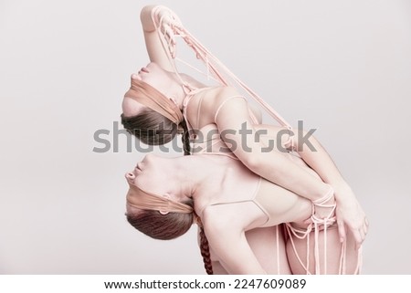 Beauty. Portrait of two young girls posing in underwear and ropes with eyes closed over light studio background. Concept of modern fashion, queer, art photography, weird people, creativity Royalty-Free Stock Photo #2247609089