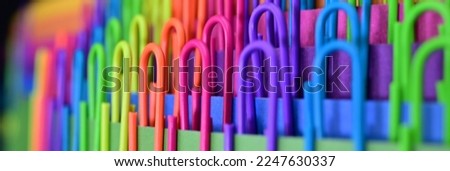Multicolored trombones or paperclips,  rainbow colors,  as a background. The concept of celebration and fun. Long banner.