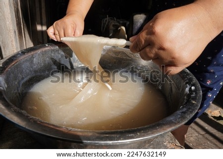 Papeda, or bubur sagu, is sago congee, a staple food of native people in Maluku Islands and West Papua. Papeda is made by cooking sago starch with water and stirring until it coagulates. Royalty-Free Stock Photo #2247632149
