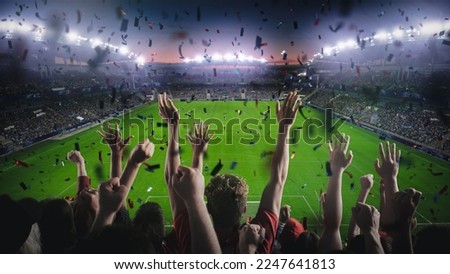Establishing Shot of Fans Cheer for Their Team on a Stadium During Soccer Championship Final Match of Season. Team Scores Goal, Crowds of Fans Celebrate Victory with Confetti. Football Cup Tournament. Royalty-Free Stock Photo #2247641813