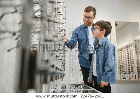 Family buy glasses. Father in a blue shirt. Royalty-Free Stock Photo #2247642981