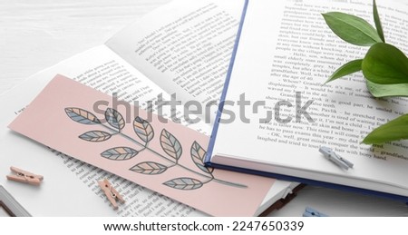 Open books with stylish bookmark on light background, closeup