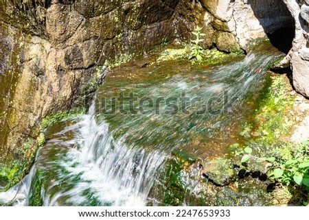 Photography on theme beautiful fall water from garden waterfall, natural texture close up, photo consisting of fall clear water with nature garden waterfall, speed fall water out garden long waterfall