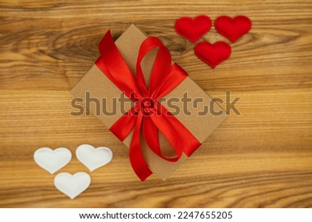 Gift box and hearts on wood background. Valentine's day
