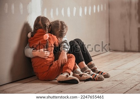 two little sister girls hugged and crying in the attic of the house, they are scared. domestic violence and a dysfunctional family with underage children Royalty-Free Stock Photo #2247655461