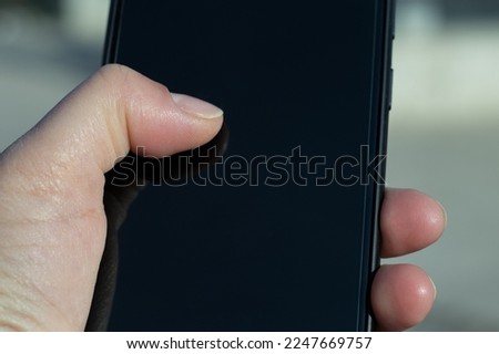 Woman holding smartphone in hand close up.