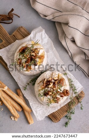 Top view of gourmet meal of white brie cheese or camembert with thyme, walnut, honey and grissini bread stick for tasty dinner Royalty-Free Stock Photo #2247673447