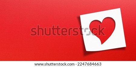 Heart shaped on note paper with panoramic red background