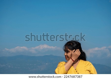 A female traveler taking picture with Mount Kanchenjunga in background.