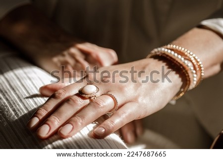 Close up picture of womans hand with gold jewelry. Royalty-Free Stock Photo #2247687665