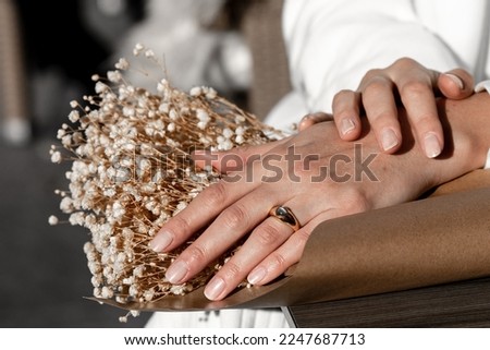 Close up picture of womans hand with gold jewelry.