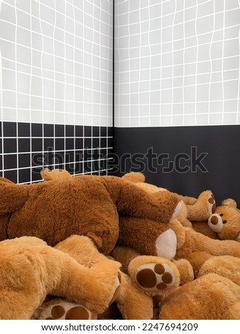 A lot of teddy bears inside a white and black room. Many fluffy bears stretched out on the floor in a room. Brown toy bears on the ground. Royalty-Free Stock Photo #2247694209