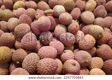 Close-up on a stack of Lychees for sale on a market stall.