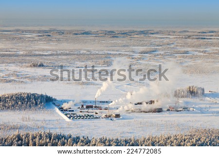 Aerial view of forest plain during a winter day. It is a top view of the oil field, which is located in forested area.