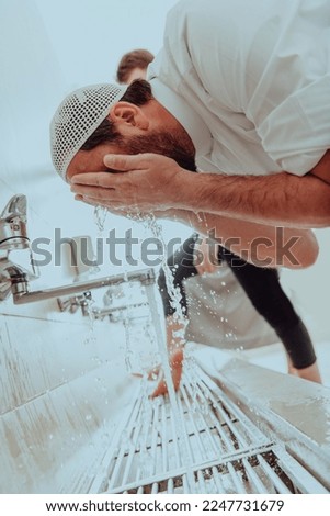 A Muslim performing ablution. Ritual religious cleansing of Muslims before performing prayer. The process of cleansing the body before prayer Royalty-Free Stock Photo #2247731679