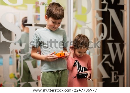 Brother with sister play remote control in children's room. Royalty-Free Stock Photo #2247736977