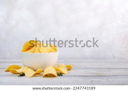Potatoes Chips. Chips in white bowl good for snack for beer on wooden table. Good for beer festival, pub, restaurant advertising. Copy space for text or logos. Royalty-Free Stock Photo #2247743189
