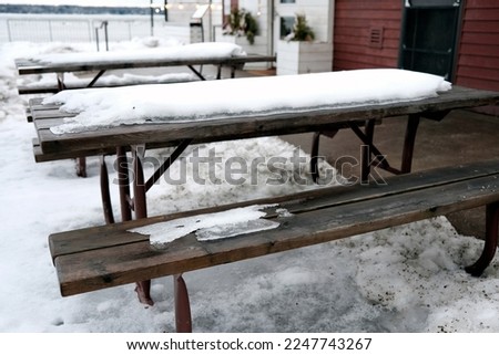 a snowy outdoor picnic table in winter